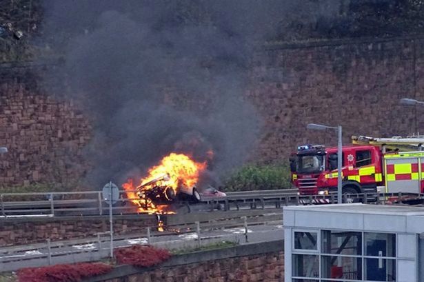 M8: Fireball car mounts crash barrier causing huge motorway delays