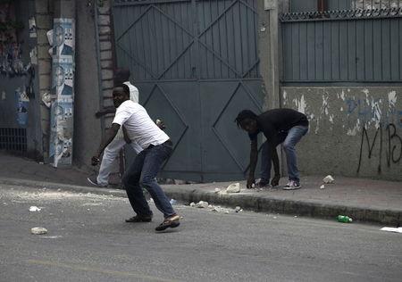 Protesters throw rocks to National Police officers during a demonstration against the electoral process in Port-au-Prince, Haiti, January 22, 2016.  REUTERS/Andres Martinez Casares