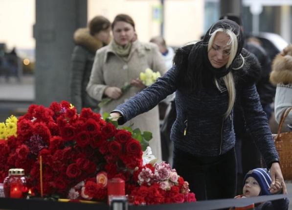 A woman lays flowers on a makeshift memorial for victims of a Russian airliner which crashed in Egypt, outside Pulkovo airport in St. Petersburg, Russia  November 1, 2015.  REUTERS/Peter Kovalev