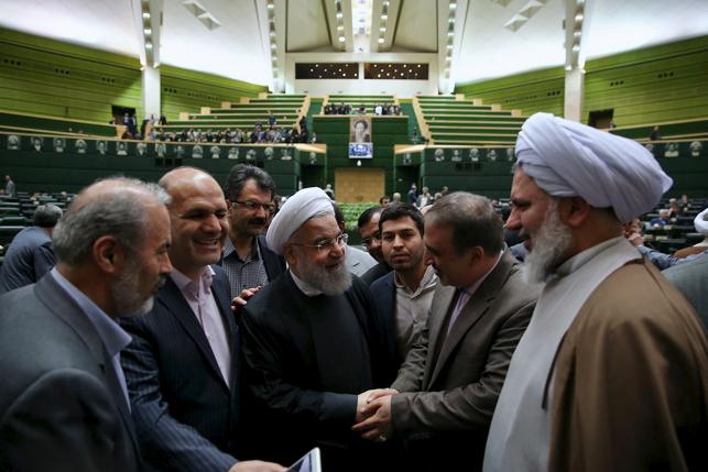 Iranian President Hassan Rouhani (C) is greeted during a session at the Iranian parliament to present the draft budget for the next Iranian fiscal year in Tehran, January 17, 2016. REUTERS/President.ir/Handout