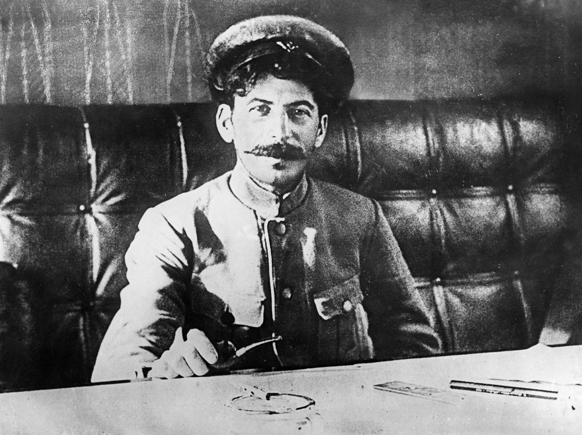 Joseph stalin sitting at a table in 1918. (Photo by: Sovfoto/UIG via Getty Images)