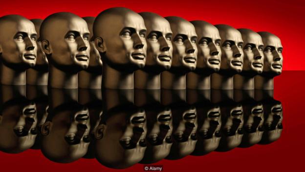 BFCNET Metallic android mannequin heads lined up in several rows on a reflective black surface with a red background