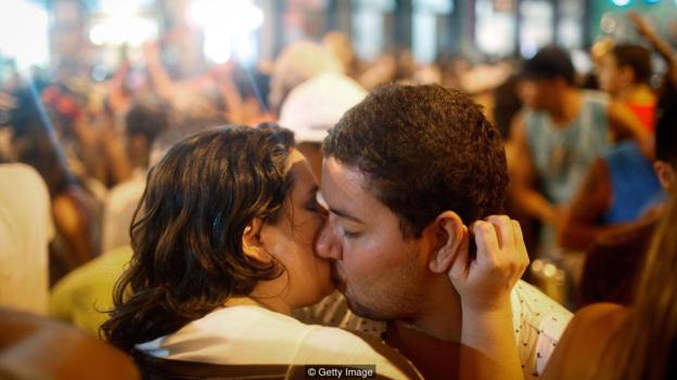 OLINDA, BRAZIL - FEBRUARY 05:  Revellers kiss during a street parade, or 'bloco', on the first official day of Carnival February 5, 2016 in Olinda, Pernambuco state, Brazil. Officials say as many as 100,000 people may have already been exposed to the Zika virus in Olinda's sister city of Recife, which is being called the epicenter of the Zika outbreak, although most people never develop symptoms. Revellers in Olinda and Recife are gathering for various concerts and street parades for Carnival.  (Photo by Mario Tama/Getty Images)