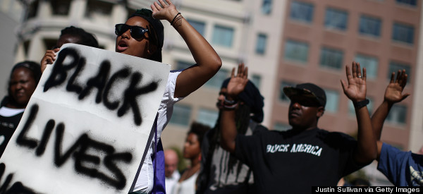 OAKLAND, CA - AUGUST 14:  Demonstrators hold their hands up during a moment of silence on August 14, 2014 in Oakland, California. Hundreds of demonstrators observed a national moment of silence in solidarity with police brutality victims including 18-year-old Michael Brown, an unarmed teen fatally shot by police in Ferguson, Missouri.  (Photo by Justin Sullivan/Getty Images)
