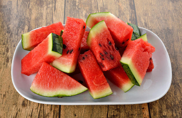 sliced watermelon on plate with wood table background