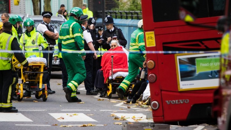 Woman trapped under London bus after it swerved to avoid crash