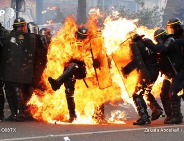 Протестующие в Париже атакуют журналистов и поджигают полицейских