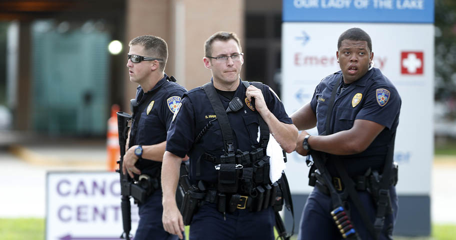 Police guard the emergency room entrance of Our Lady Of The Lake Medical Center, where wounded officers were brought, in Baton Rouge, La., Sunday, July 17, 2016. Multiple law enforcement officers were killed and wounded Sunday morning in a shooting near a gas station in Baton Rouge, less than two weeks after a black man was shot and killed by police here, sparking nightly protests across the city. (AP Photo/Gerald Herbert)